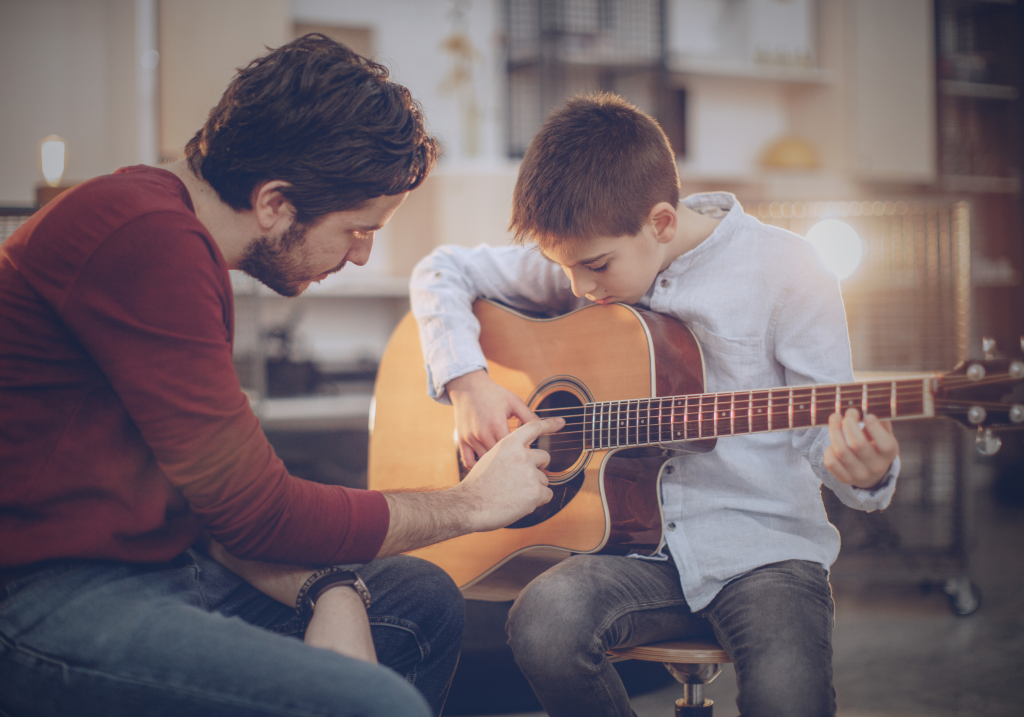 boy learning how to play guitar